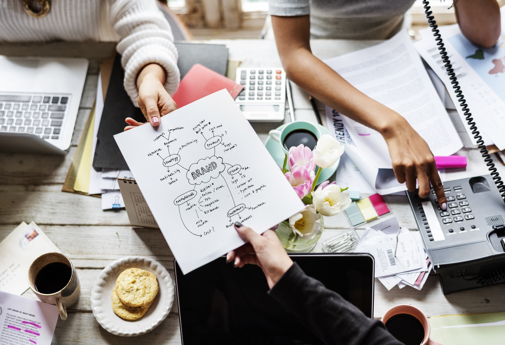 colleagues handing branding plan strategy to other